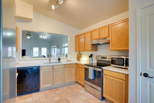 a large kitchen with wooden cabinets and appliances at Sunny Surprise Getaway with Private Yard and Pool in Surprise