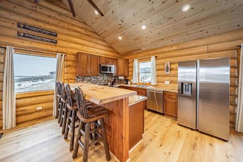 a kitchen with a refrigerator and wooden walls at Log Cabin Teton Views & Pets OK in Tetonia