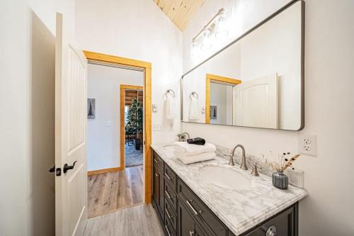 a bathroom with a sink and a large mirror at Log Cabin Teton Views & Pets OK in Tetonia
