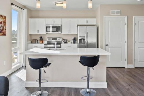 una cucina con bancone bianco e 2 sgabelli da bar di Unit 45 Well designed 1BR Apartment Long term stays a Chelsea