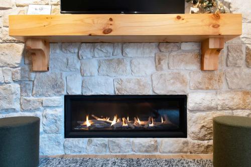 a stone fireplace with a fire in it at Tranquil Retreat Hot Tub Shuttle in Driggs