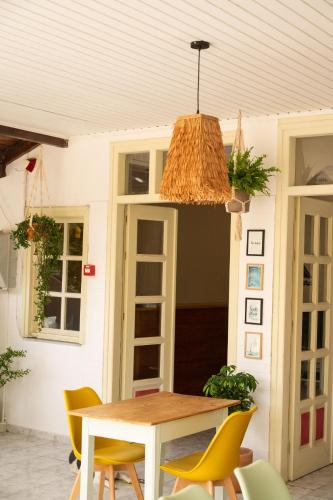 a dining room table with yellow chairs and a ceiling at Pension Romantika in Matala