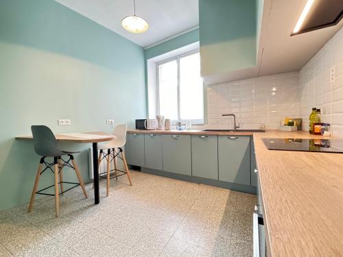 une cuisine avec une table et des chaises dans une pièce dans l'établissement Maison familial pour 6 à 8 personnes animaux acceptés, à Ferrals-lès-Corbières