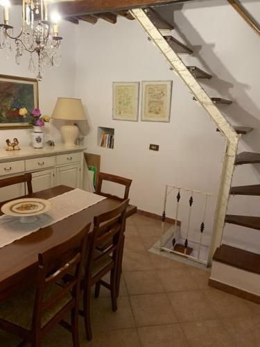 a dining room with a table and chairs and a staircase at Il bricco in Forno