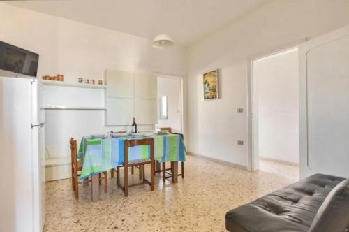 a kitchen with a table with chairs and a refrigerator at Aura apartaments in Torre Lapillo