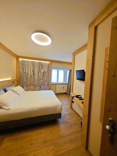 a hotel room with a bed and a window at Da Gigi Alpine Rooms in Crandola Valsassina