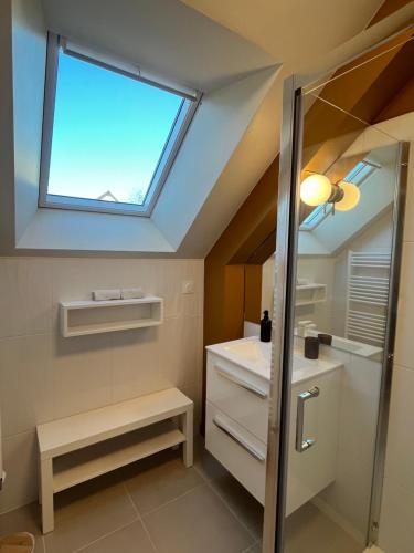 La salle de bains est pourvue d'une lucarne, d'un lavabo et d'un miroir. dans l'établissement Villa Bambou, à Saint-Jouan-des-Guérets