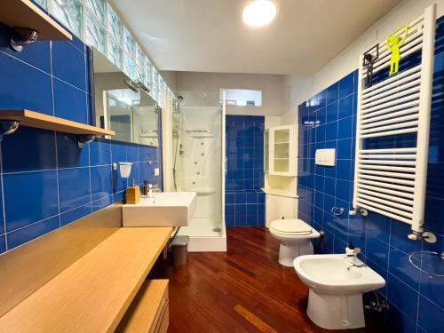 a blue bathroom with two toilets and a sink at Centro Jesi Elegant Apartment in Iesi