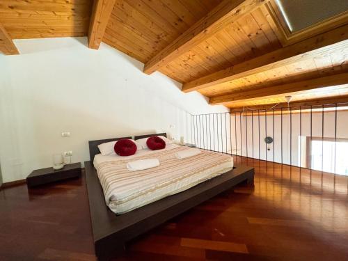 a bedroom with a bed with two red pillows on it at Centro Jesi Elegant Apartment in Iesi
