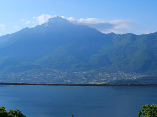 a train traveling across a lake with a mountain at Naturstein-Rustiko Casa Marie in Vercana