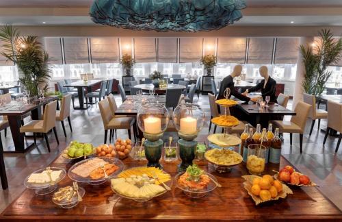 a table with food on it in a restaurant at Hotel Inglaterra - Charme & Boutique in Estoril