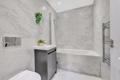 a bathroom with a tub and a toilet and a sink at Travard at Heathrow 386a in Harmondsworth