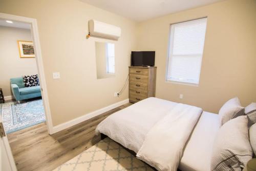 a bedroom with a bed and a dresser and a window at Unit 23 Comfy 1BR Apartment Long-term stays in Chelsea
