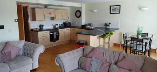 a living room with two couches and a kitchen at Marina View in Milford Haven
