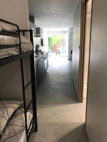 une chambre avec des lits superposés et une cuisine et un couloir dans l'établissement Studio La grande Motte, à La Grande Motte