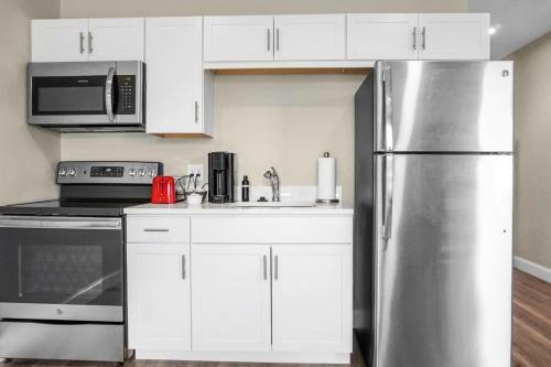 Una cocina con gabinetes blancos y un refrigerador de acero inoxidable. en Unit 26 Chic Studio in Chelsea, en Chelsea