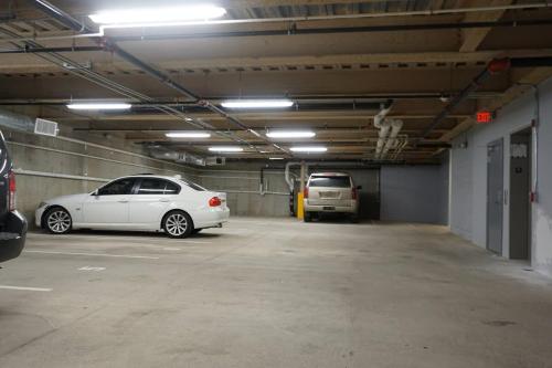 a parking garage with two cars parked in it at Unit 32 Stylish 1BR 1BA Apartment Long-term stays in Chelsea