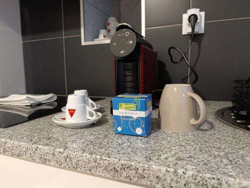 a counter top with a coffee maker and cups on it at Sundaze in Fenais da Luz