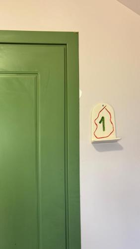 a green door with a sign on the wall at Limonura in Tsikhisdziri