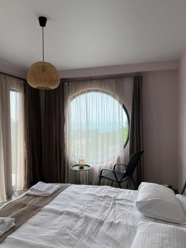 a bedroom with a large bed and a large window at Limonura in Tsikhisdziri