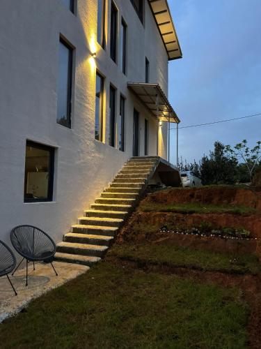 a building with a set of stairs and a chair at Limonura in Tsikhisdziri