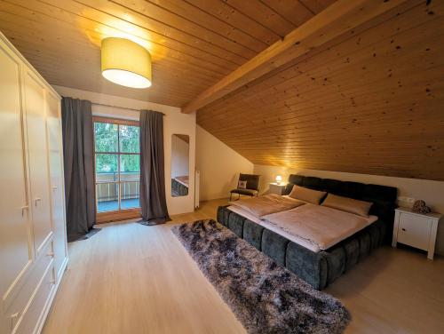 a bedroom with a large bed in a wooden ceiling at AlpenAuszeit in Oy-Mittelberg