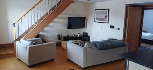 a living room with two chairs and a staircase at Marina Outlook in Milford Haven