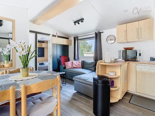 une cuisine de caravane et un salon avec une table et un canapé dans l'établissement Mobil-Home MA 62 à Vias - La Carabasse - Camping Siblu avec piscine, à Vias