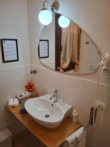 a bathroom with a sink and a mirror at L'Oasi del Mediterraneo in Sampieri