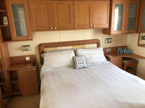a bed with a book sitting on top of it at Millfield caravan site, caravan L6 in Ingoldmells