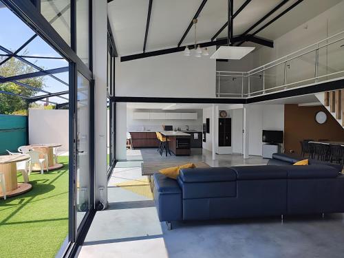 un salon avec un canapé bleu dans une pièce dans l'établissement Loft lumineux, pièce de vie 100m2, parking privé, à Le Mesnil-Esnard