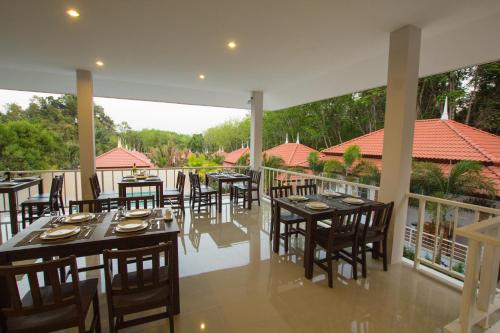 a restaurant with tables and chairs on a balcony at Lux Family Villas Krabi Ao Nang in Ao Nang Beach