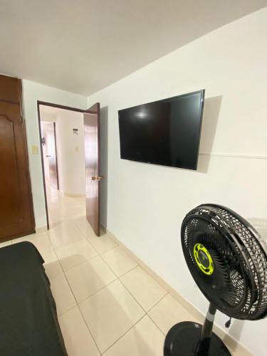 a room with a fan and a television on a wall at Hermoso apartamento cerca al Poblado in Medellín