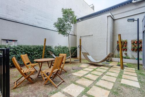 a patio with a table and chairs and a hammock at Estadia completa com piscina, próximo ao metrô e à Praça da Sé – APS in Sao Paulo