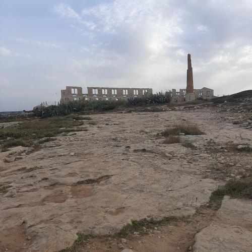 an old building on a hill with a clock tower at L'Oasi del Mediterraneo in Sampieri
