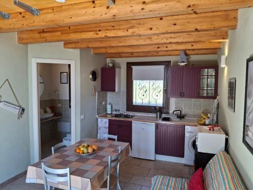 a kitchen with a table and a dining room at L'Oasi del Mediterraneo in Sampieri