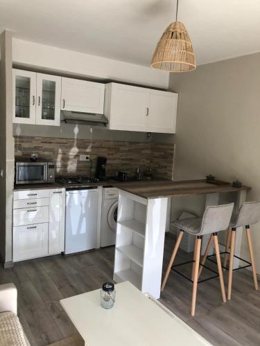 une cuisine avec des armoires blanches et une table et des chaises dans l'établissement La catane, à Andon