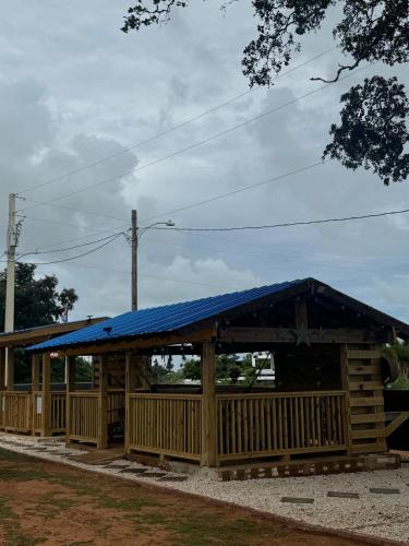 a large wooden building with a blue roof at House with a jacuzzi and solar panels in Boqueron