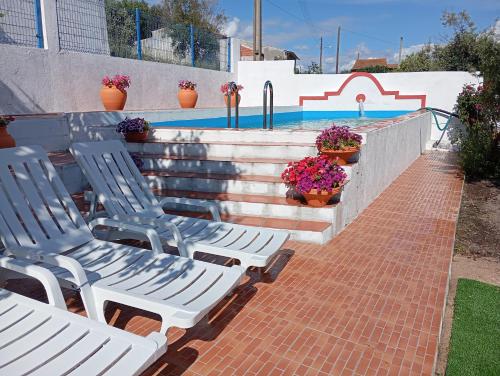 two white chairs sitting next to a swimming pool at CASA DA ALDEIA - Ponte de Sor (Alentejo) in Ponte de Sor