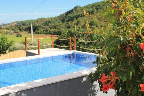 a swimming pool in the middle of a house with a mountain at Refúgio da Serra in Portalegre