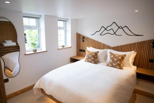 ein Schlafzimmer mit einem weißen Bett mit Bergen an der Wand in der Unterkunft Tucked Away in Keswick