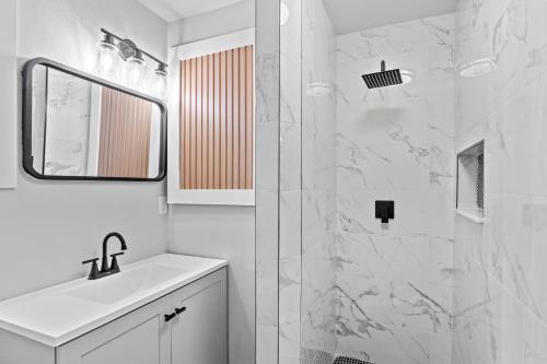 a white bathroom with a sink and a mirror at Palms Retreat in Central Largo - mins to the Sand! in Largo