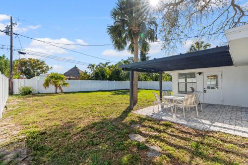 a house with a table and chairs in a yard at Palms Retreat in Central Largo - mins to the Sand! in Largo