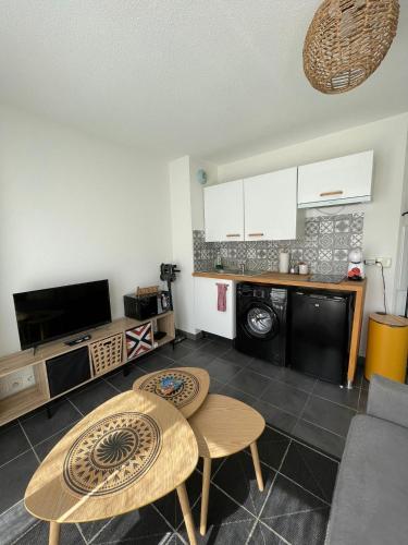 un salon avec une table et une cuisine dans l'établissement Charmant studio climatisé avec terrasse ensoleillée, à Nice