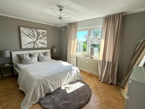 a bedroom with a white bed and a window at Schöne Ferienwohnung in Ense