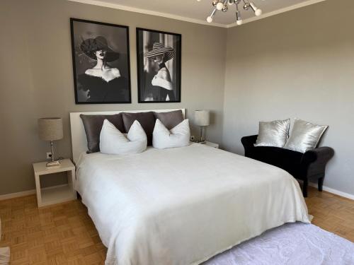 a bedroom with a large white bed and a chair at Schöne Ferienwohnung in Ense