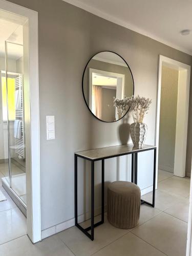 a mirror in a room with a table and a stool at Schöne Ferienwohnung in Ense