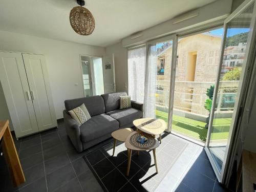un salon avec un canapé et une table dans l'établissement Charmant studio climatisé avec terrasse ensoleillée, à Nice