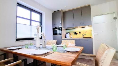 a dining room table with chairs and a kitchen at CBlue "Zickerstuuv", Wasserblick, in der Natur, Grill in Groß Zicker