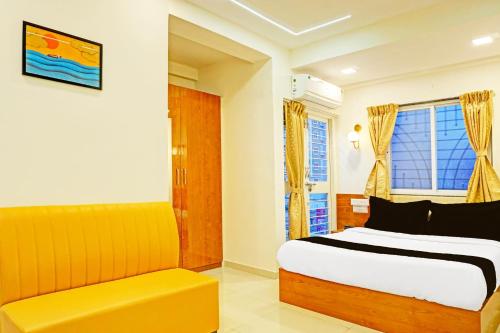 a bedroom with a bed and a yellow couch at Townhouse Surya Inn in Pune